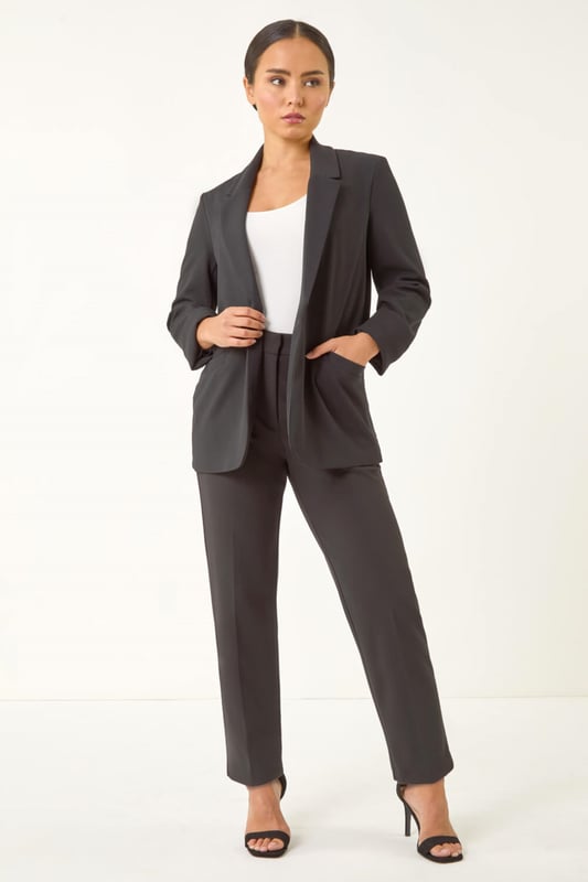 Petite Revere Collar Stretch Blazer Petite Revere Collar Stretch Blazer from Roman. Upgrade your Spring/Summer wardrobe with this chic stretch blazer. Effortlessly stylish, this blazer features a sophisticated revere collar and a pull-on style for easy wear. The long set-in sleeves with roll-up cuffs add a touch of versatility. Cut to a flattering hip-length in a comfortable stretch fabric, this blazer is the perfect choice for adding a smart touch to any outfit. Pair it with a floral dress and heels for a polished and put-together look.
