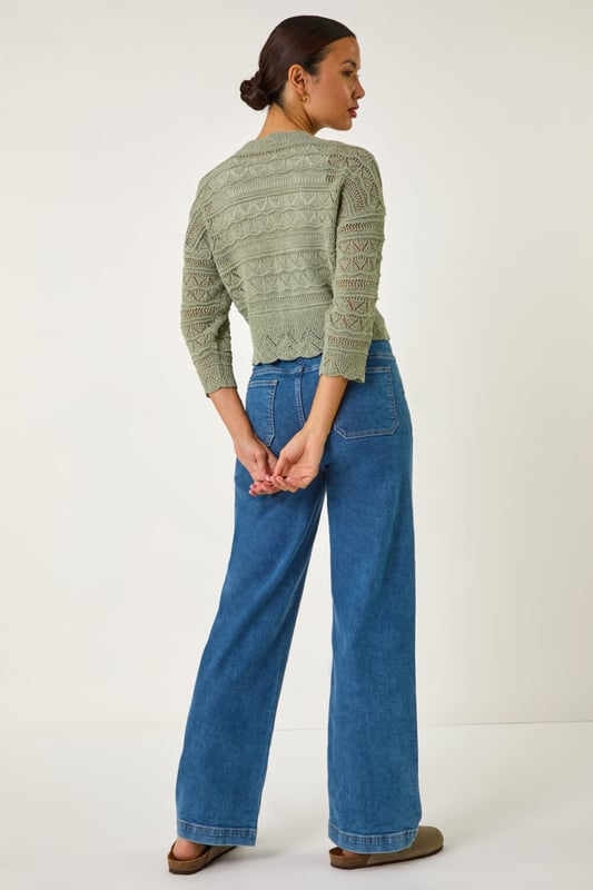 Textured Scallop Shrug from Roman. Add a touch of elegance to your outfit with this stunning scallop shrug, perfect for the Spring/Summer season. Crafted from textured tape yarn, this shrug features chic 3/4 sleeves and a soft hand touch for ultimate comfort. The scallop detailing adds a fun and stylish twist to the classic shrug style. Pair it with a simple t-shirt and jeans for a casual yet sophisticated look that can take you from day to night effortlessly.