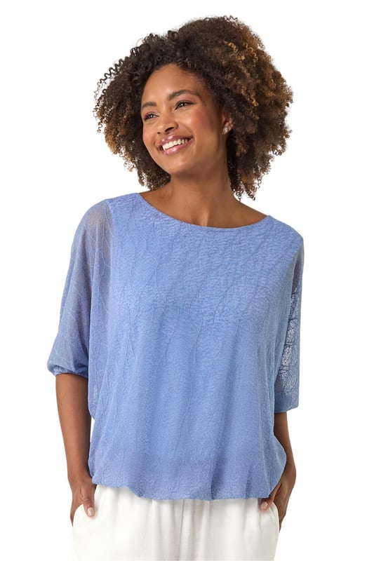 Mesh Bubble Hem Stretch Top from Roman. This stylish top is crafted from soft jersey fabric and features a round neckline and 3/4 sleeves for a comfortable fit. The bubble hem detail adds a playful and flattering touch, while the textured fabric gives it an extra layer of sophistication. Pair it effortlessly with jeans and sandals for a chic, relaxed look perfect for Spring or Summer outings.
