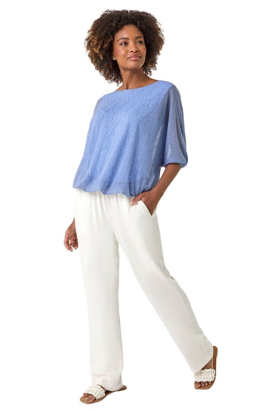 Mesh Bubble Hem Stretch Top from Roman. This stylish top is crafted from soft jersey fabric and features a round neckline and 3/4 sleeves for a comfortable fit. The bubble hem detail adds a playful and flattering touch, while the textured fabric gives it an extra layer of sophistication. Pair it effortlessly with jeans and sandals for a chic, relaxed look perfect for Spring or Summer outings.