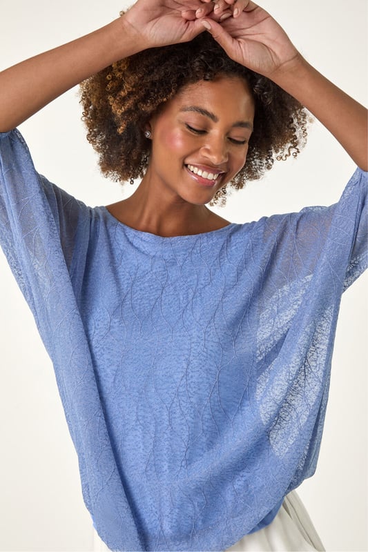 Mesh Bubble Hem Stretch Top from Roman. This stylish top is crafted from soft jersey fabric and features a round neckline and 3/4 sleeves for a comfortable fit. The bubble hem detail adds a playful and flattering touch, while the textured fabric gives it an extra layer of sophistication. Pair it effortlessly with jeans and sandals for a chic, relaxed look perfect for Spring or Summer outings.