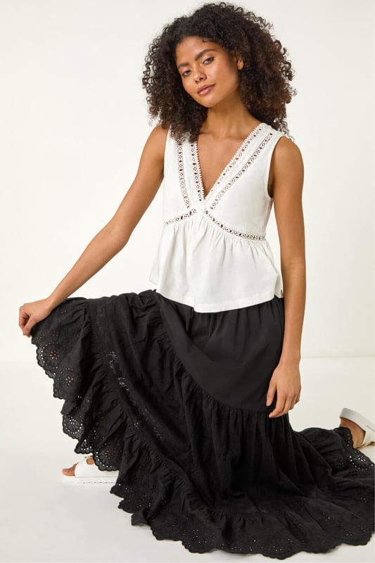 Dusk Tiered Broderie Maxi Skirt from Roman. Embrace summer vibes with this delightful tiered broderie skirt. The intricate broderie design adds a charming touch to this maxi length skirt, perfect for sunny days. The tierred style adds flow and movement to your look, creating an effortlessly feminine silhouette. Pair it with a simple cami top and sandals for an easy-breezy summer outfit that will keep you cool and stylish all day long.