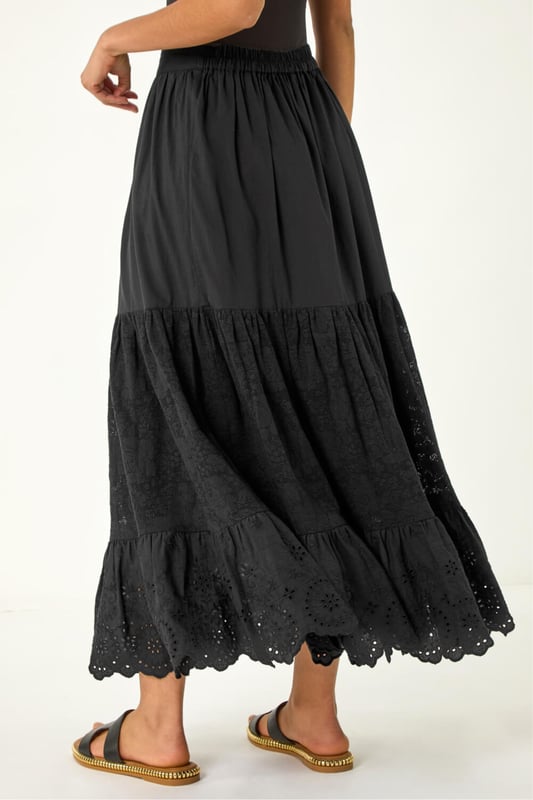 Dusk Tiered Broderie Maxi Skirt from Roman. Embrace summer vibes with this delightful tiered broderie skirt. The intricate broderie design adds a charming touch to this maxi length skirt, perfect for sunny days. The tierred style adds flow and movement to your look, creating an effortlessly feminine silhouette. Pair it with a simple cami top and sandals for an easy-breezy summer outfit that will keep you cool and stylish all day long.