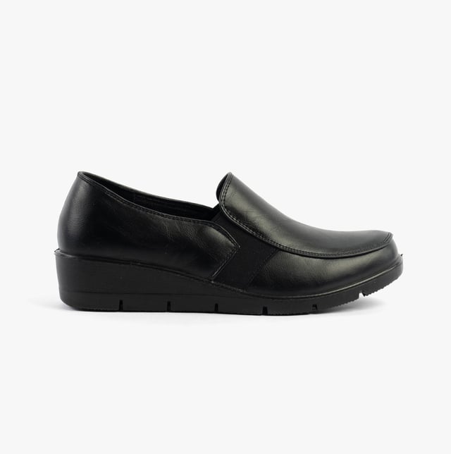 These casual women's slip-on shoes feature a leather upper, textile lining, rubber sole, and a low wedge heel, offering comfort and a wide fit for everyday wear