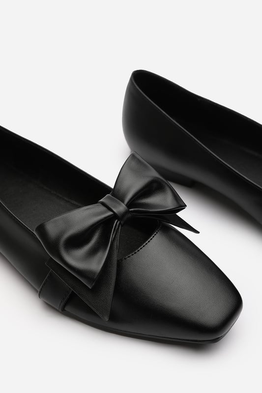 Wheres That From Womens 'Kaitlyn' Square Toe Ballet Flats With Bow Detail Step into polished perfection with these Kaitlyn Square Toe Ballet Flats With Bow Detail. Featuring a sleek square toe and oversized bow detail, they bring a playful yet sophisticated touch to any outfit. The slip-on design and cushioned sole ensure lasting comfort throughout the day. Ideal for office wear, special occasions, or elevating your everyday style. Key Features: • Material: Faux leather with soft inner lining • Design: Square toe silhouette with large statement bow • Closure: Slip-on style for easy wear