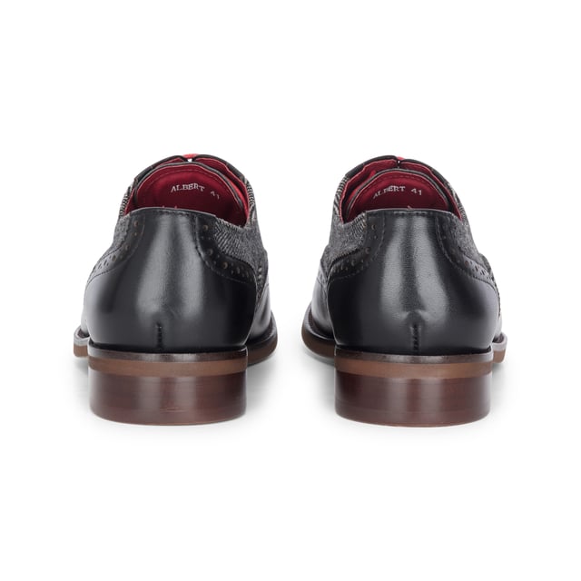 Make a refined impression with the Justin Reess Albert Black Leather Brogues. Blending smooth leather with textured tweed, these formal shoes offer a smart twist on a classic style. Perfect for weddings, work events, or evenings out, they combine comfort, detail, and durability in one polished design.

Black Leather Upper for a sleek, timeless look

Tweed Fabric Panels add texture and unique style

Classic Brogue Detailing with wingtip accents

Lace-Up Fastening for a secure and adjustable fit

Cushioned Insole for enhanced comfort during long wear

Durable Sole for traction and longevity

Perfect for Formal Events, business attire, or smart-casual outfits