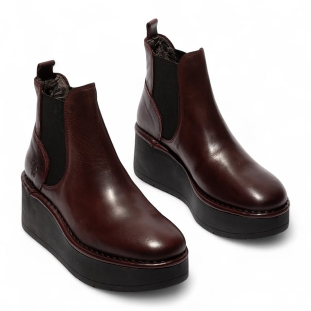 Veredeln Sie Ihren Herbst-Look mit den Fly London HELY268FLY Stiefeletten. Dieses auffällige Modell mit dicker Plateausohle und hohem Absatz sorgt für einen markanten, modernen Look. Das glatte Obermaterial aus Leder ist mit elastischen Seiteneinsätzen kombiniert, wodurch sich die Stiefel leicht an- und ausziehen lassen und gleichzeitig bequem sitzen. Mit dem charakteristischen Viertelstempel von Fly London und einem 7,5 cm hohen Absatz vereinen diese Stiefel Mode und Funktionalität perfekt – ideal für den Alltag oder zum Aufpeppen lässiger Outfits. Obermaterial: Leder, Futter: Mikrofaser, Laufsohle: TR-Gummi, Absatzhöhe: 7,5 cm, Innensohle: Mikrofaser, Stil: Zum Hineinschlüpfen mit elastischen Seiteneinsätzen, Eigenschaften: Plateausohle, Komfort