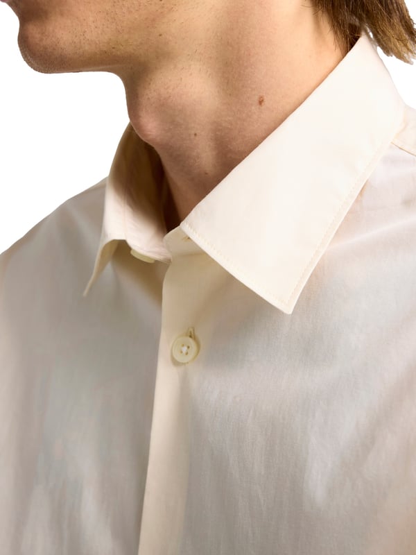 Dieses klassische Herrenhemd bringt zeitlose Eleganz in eine moderne Silhouette. Mit lockerem Schnitt und überschnittenen Schultern sorgt es für eine entspannte Passform und lässige Ausstrahlung. Der markante Kent-Kragen unterstreicht den gepflegten Look, ob mit oder ohne Krawatte. Die durchgehende Knopfleiste macht das Anziehen unkompliziert und vielseitig kombinierbar. Ein abgerundeter Saum lässt das Hemd auch offen getragen stilvoll wirken. Verstellbare 2-Knopf-Manschetten bieten Flexibilität und eine individuelle Passform. Das hochwertige Material liegt angenehm auf der Haut und garantiert ganztägigen Tragekomfort. Ideal für Büro, Freizeit, City-Style oder festliche Anlässe – dieses Hemd macht überall eine gute Figur. Dezente Details sorgen für einen stimmigen Gesamteindruck. Ein Must-have für Männer mit Gespür für Klassiker mit modernem Twist.