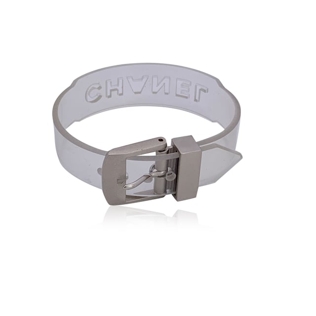 VINTAGE, RRP AS NEW
Add a playful twist of luxury to your collection with this lovely CHANEL bracelet, a rare and striking piece that fuses bold branding with unexpected materials. Crafted in clear transparent rubber, it's a standout example of late '90s CHANEL design-where classic elegance met avant-garde edge.  The bracelet features cut-out CHANEL lettering that runs boldly across its surface, allowing light to pass through for a modern, sculptural look. A buckle closure adds an industrial-chic touch, keeping the fit secure and adjustable.  Stamped with the 'Chanel 99 CC S Made in France' hallmark near the closure, this piece dates to 1999, offering collectors a glimpse into one of the brand's more experimental eras. At 8.25 inches (21 cm) in total length, it's designed to fit comfortably on most wrists.  Whether worn solo as a statement or layered with fine bangles for contrast, this bracelet is a perfect blend of vintage charm and futuristic flair-unmistakably CHANEL, and effortlessly cool. Condition Rating: A - EXCELLENTCondition Details: Minimal wear of use on rubber. Please, look carefully at the photos and ask for any detail.  Box?: ?: No Measurments:  length: 210 mm