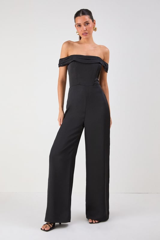 Elegant Bardot neckline with sophisticated folded detail for a striking off-shoulder silhouette
        Luxurious satin fabric that catches the light beautifully as you move
        Flattering structured bodice that enhances your natural shape
        Dramatic wide leg design offering both comfort and statement style
        Floor-sweeping length perfect for creating a statuesque appearance
    
    Command attention at your next special occasion in this show-stopping Misspap jumpsuit. The striking Bardot neckline frames your dcolletage whilst the structured bodice creates a flattering silhouette that transitions into flowing wide legs for dramatic effect. Style with statement earrings and sleek heels as seen on our model for maximum impact at formal events. This versatile piece works brilliantly for weddings, graduation ceremonies or evening soires - simply switch up your accessories to suit the occasion. For cooler evenings, layer with a tailored blazer or delicate wrap without compromising on glamour. The all-in-one design offers effortless sophistication whilst ensuring you stand out from the crowd.