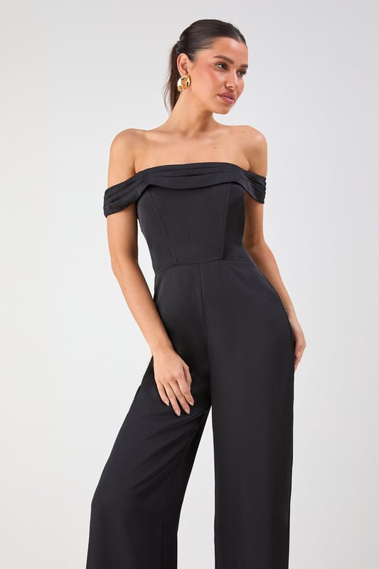 Elegant Bardot neckline with sophisticated folded detail for a striking off-shoulder silhouette
        Luxurious satin fabric that catches the light beautifully as you move
        Flattering structured bodice that enhances your natural shape
        Dramatic wide leg design offering both comfort and statement style
        Floor-sweeping length perfect for creating a statuesque appearance
    
    Command attention at your next special occasion in this show-stopping Misspap jumpsuit. The striking Bardot neckline frames your dcolletage whilst the structured bodice creates a flattering silhouette that transitions into flowing wide legs for dramatic effect. Style with statement earrings and sleek heels as seen on our model for maximum impact at formal events. This versatile piece works brilliantly for weddings, graduation ceremonies or evening soires - simply switch up your accessories to suit the occasion. For cooler evenings, layer with a tailored blazer or delicate wrap without compromising on glamour. The all-in-one design offers effortless sophistication whilst ensuring you stand out from the crowd.