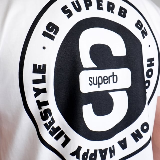 Add a modern twist to your wardrobe with this short-sleeved T-shirt from Superb. With a clean design on the front and a striking graphic on the back, this piece is ideal for those who appreciate a streetwear style with a sense of style.\\n\\n Details:\\n - S logo embroidered on the left chest.\\n - Circular print with the text “Hooked on a Happy Lifestyle” and the Superb logo on the back.\\n - Straight silhouette that easily adapts to all body types.\\n - Reinforced round neck.\\n\\n Whether for casual outings or as part of an urban outfit, this Superb men's t-shirt is the perfect companion. With timeless style and bold graphic details, you'll stand out without sacrificing comfort.\\n Composition: 100% Cotton\\n Care:\\nMachine wash cold, with like colors.\\n Do not use bleach.\\n Do not use a dryer.