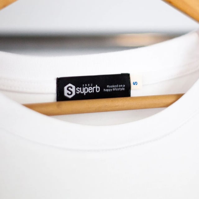Een statementmaker. Dit Superb T-shirt combineert een minimalistische stijl met een streetwear touch dankzij de losse pasvorm en het cleane ontwerp. Perfect voor ontspannen looks die opvallen.Details:\\n - Extra oversized snit, met afgezakte schouders voor een casual en moderne pasvorm.\\n - Brede dubbele stiksels op manchetten en zoom.\\n - Toon-op-toon geborduurd Superb logo op de borst voegt een subtiel vleugje branding toe.\\n - Verstevigde ronde hals, comfortabel en duurzaam.\\n - Zachte en duurzame stof, ideaal voor dagelijks gebruik.\\n Een veelzijdig oversized T-shirt met attitude voor wie op zoek is naar een moeiteloze stijl. Materiaal: 97% Katoen, 3% Elasthan™ Onderhoud: machinewasbaar op maximaal 30°C. Niet bleken, strijken op lage temperatuur, niet in de droger.
