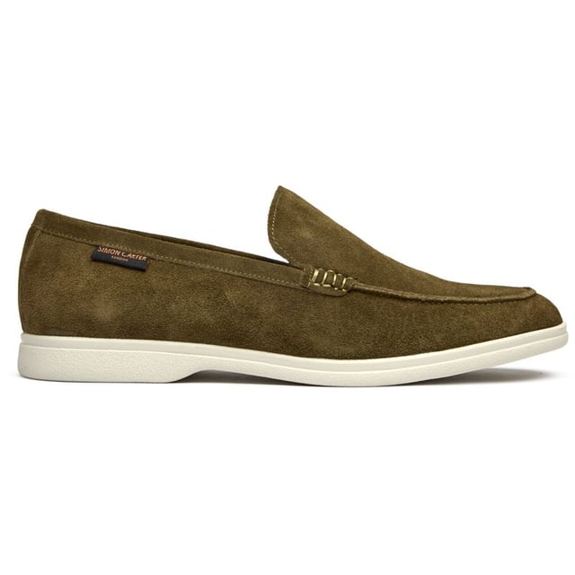 The Simon Carter Tanius Slip On brings style to contemporary menswear with its rich green suede construction and dinosaur print lining. These premium loafers feature luxurious leather sock and lining for all-day comfort, while the durable rubber sole ensures reliable traction. Complete with an exclusive branded shoe bag, they're perfect for the modern gentleman who appreciates distinctive details and museum-quality craftsmanship.