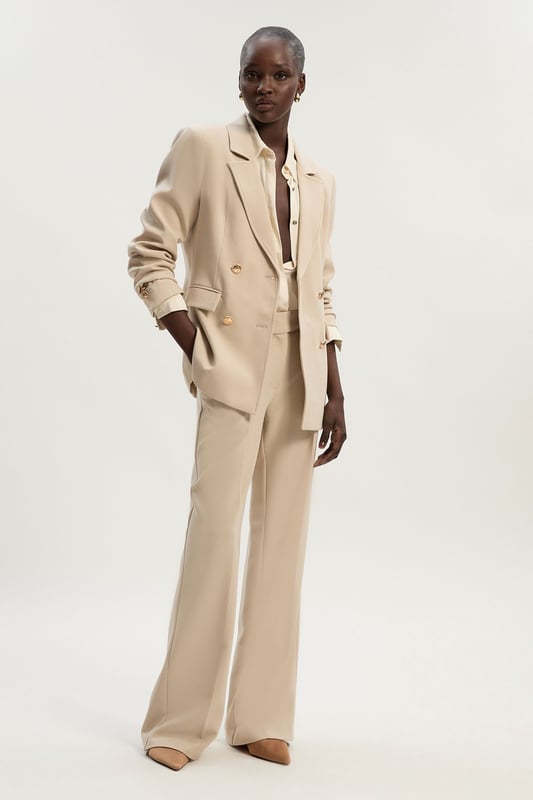 A sculptural rendition of the classic blazer, this piece offers endless sophistication. Sharp tailoring and double-breasted buttons create a cinched silhouette, while classic notched lapels and flap pockets add a traditional touch. Style this blazer with co-ordinating tailored trousers for a powerful ensemble, or size up for a contemporary, oversized aesthetic.Notched collarDouble breastedTailored Browse this seasons suits now.