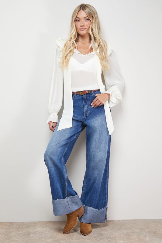 Distinctive turnup hem detail creates a contemporary silhouette
        Straight leg design offers a relaxed, comfortable fit
        High-rise waistband for a flattering shape
        Classic five-pocket styling with traditional stitching
        Wide leg opening with substantial cuff detail for a fashion-forward look
    
    These Oasis denim straight leg jeans combine timeless style with modern detailing. The relaxed fit and statement turnup hem create a fresh, contemporary look that's perfect for everyday wear. Style with a simple white tee and tan accessories for an effortlessly chic daytime ensemble, or pair with a floral blouse and ballet flats for weekend brunches and casual gatherings. The versatile straight leg silhouette works beautifully with both fitted and oversized tops, making these jeans a true wardrobe staple. For cooler days, layer with an oversized cardigan or denim jacket and trainers for a casual yet put-together look. The high-rise waist and relaxed fit through the leg ensure all-day comfort without compromising on style.