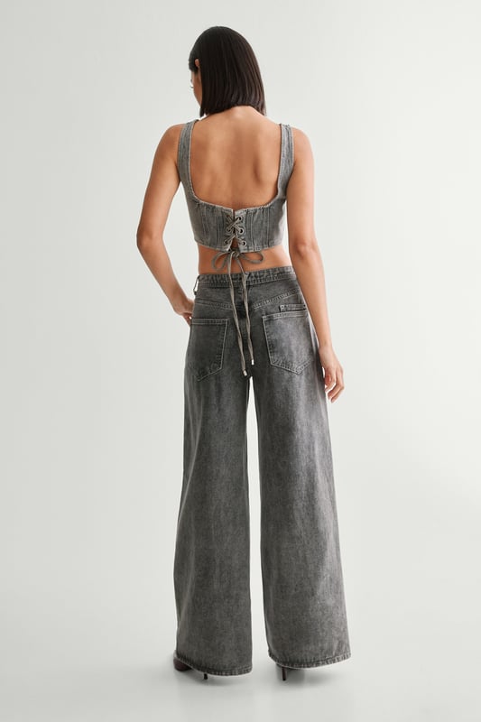 Striking lace-up detail along the sides
        High-waisted design for a flattering silhouette
        Wide-leg cut for a trendy, relaxed look
        Cropped top with square neckline and thick straps
        Back lace-up closure on the top for adjustable fit
    
    Make a bold statement with these eye-catching jeans from NastyGal. The standout lace-up detail running along the sides adds a daring edge to your casual ensemble. Pair with the matching cropped top for a coordinated look that's sure to turn heads. The high-waisted, wide-leg cut is perfect for creating a long, lean silhouette. Style with chunky trainers for a laid-back vibe, or dress up with heeled boots for evening drinks. These versatile jeans are ideal for family gatherings, brunches with friends, or casual Friday at the office. The denim fabric offers comfort and durability, making these jeans a wardrobe staple you'll reach for time and time again.