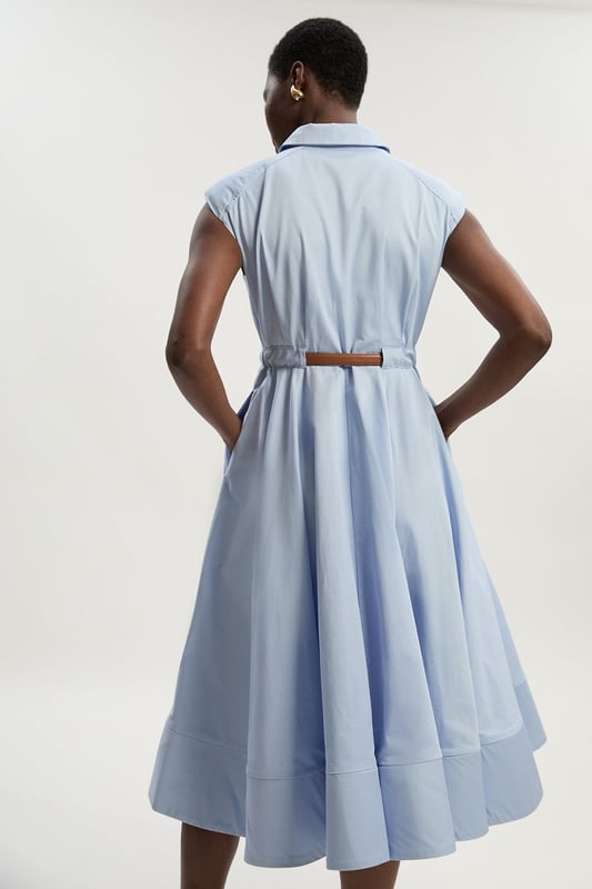 This Karen Millen collared midi dress combines timeless sophistication with practical daywear comfort. The structured silhouette features thoughtful pleating that creates a flattering A-line shape, whilst the included belt cinches the waist for a customised fit. Style with flat sandals and a woven tote for weekend brunches, or dress it up with ballet flats and a cardigan for family gatherings. The cotton fabric ensures this piece remains a comfortable choice for all-day wear, making it an essential addition to your casual-stylish wardrobe.  Crafted from pure cotton for breathable comfort Tailored silhouette with structured collar and cap sleeves Matching belt with gold-tone buckle Full midi skirt with pleating detail Button-through front design