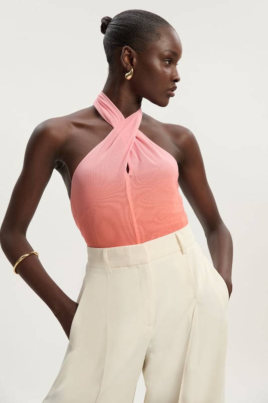 This eye-catching Karen Millen bodysuit combines contemporary design with effortless wearability. The cross halter neckline frames the decolletage beautifully, whilst the ombre mesh effect creates visual interest that catches the light as you move. Style with wide-leg trousers as shown for a balanced silhouette that's perfect for summer gatherings or casual brunches. The jersey fabric offers comfortable stretch that moulds to your shape without feeling restrictive. For daytime events, pair with tailored shorts and flat sandals, or dress up with a flowing midi skirt and statement earrings for evening drinks. Layer with a lightweight blazer when temperatures drop for a look that transitions seamlessly from day to night. This versatile piece works wonderfully for family celebrations or casual meet-ups with friends.  Striking cross halter neckline creating an elegant silhouette Captivating ombre mesh design Figure-enhancing jersey bodysuit with comfortable stretch Sleek open back design Secure halterneck fastening