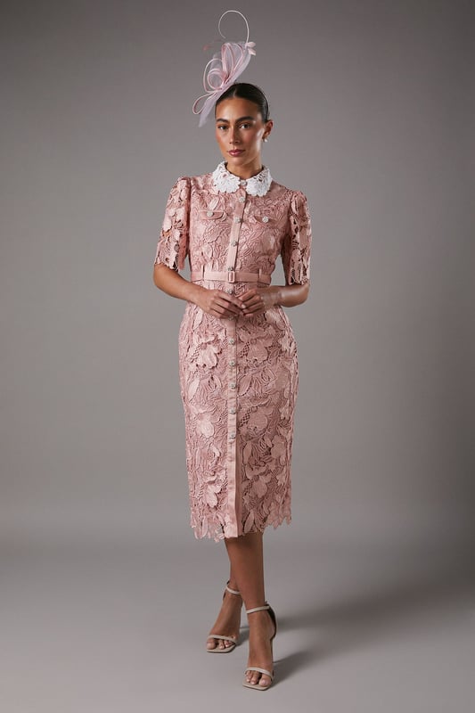 Exquisite lace overlay with intricate floral pattern
        Contrasting white collar for a striking visual effect
        Elegant midi length with a sophisticated side slit
        Short puff sleeves with delicate scalloped edges
        Button-down front for a classic shirt dress silhouette
    
    This stunning lace shirt dress from Coast is the epitome of refined elegance. The intricate floral lace overlay creates a captivating visual texture, while the contrasting white collar adds a touch of sophistication. Perfect for formal occasions, this dress can be styled with strappy heels and statement earrings for a wedding or the races. The midi length and side slit offer a flattering silhouette, allowing for graceful movement. For a more versatile look, pair it with pointed-toe court shoes and a clutch bag for an evening soire. The button-down front and collared neckline give a nod to classic tailoring, making this dress a timeless addition to your occasion wear collection. Whether you're attending a graduation ceremony or a garden party, this Coast dress will ensure you stand out with its blend of traditional charm and contemporary allure.