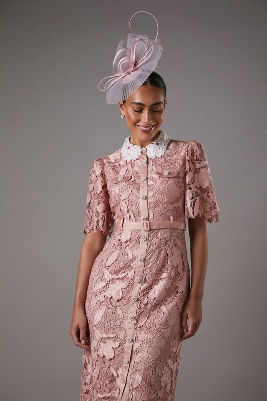 Exquisite lace overlay with intricate floral pattern
        Contrasting white collar for a striking visual effect
        Elegant midi length with a sophisticated side slit
        Short puff sleeves with delicate scalloped edges
        Button-down front for a classic shirt dress silhouette
    
    This stunning lace shirt dress from Coast is the epitome of refined elegance. The intricate floral lace overlay creates a captivating visual texture, while the contrasting white collar adds a touch of sophistication. Perfect for formal occasions, this dress can be styled with strappy heels and statement earrings for a wedding or the races. The midi length and side slit offer a flattering silhouette, allowing for graceful movement. For a more versatile look, pair it with pointed-toe court shoes and a clutch bag for an evening soire. The button-down front and collared neckline give a nod to classic tailoring, making this dress a timeless addition to your occasion wear collection. Whether you're attending a graduation ceremony or a garden party, this Coast dress will ensure you stand out with its blend of traditional charm and contemporary allure.