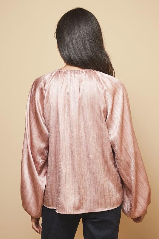 Luxurious shimmer satin blouse with elegant gathered neckline detail
        Voluminous balloon sleeves with fitted cuffs for a dramatic silhouette
        Relaxed fit through the body offering comfortable wear for all-day events
        Crew neckline with subtle pleating that catches the light beautifully
        Versatile design that transitions effortlessly from day to evening occasions
    
    This captivating Shimmer Satin Blouse from Wallis radiates sophistication with its lustrous finish and considered design details. The gathered crew neckline creates a flattering frame for statement jewellery, whilst the sumptuous balloon sleeves add a touch of drama to your ensemble. Style as shown with wide-leg trousers and a structured handbag for an elegant workwear look, or pair with a tailored pencil skirt and heels for formal occasions such as weddings or race days. The fluid drape of the fabric moves gracefully with you, ensuring you feel as confident as you look. For evening events, complement with statement earrings and a clutch bag to showcase the blouse's light-reflecting qualities. This versatile piece works beautifully layered under tailored blazers for a refined approach to occasion dressing.
