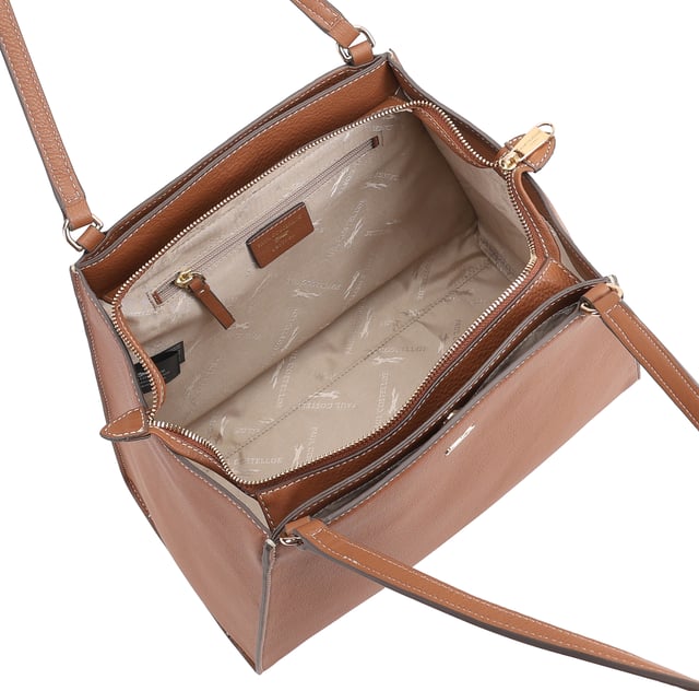 This uniquely shaped leather tote bag combines elegance with practicality, featuring a spacious central compartment secured by a top zip, perfect for work or casual outings. It offers convenient organization with external slip pockets on both sides, an internal zip pocket, and an additional slip pocket inside. Designed for comfort, the long shoulder handles make it easy to carry all day, while the clean silhouette is elevated by a sleek metal logo pin for a touch of refined style. D:18cm W:42.5cm H:27.5