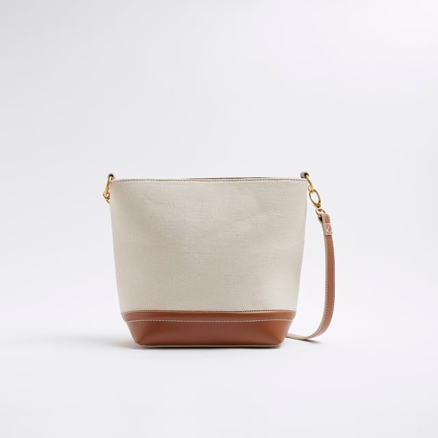 River Island Womens Cream Canvas Bucket Bag Canvas fabric, RR pendant, Lock detail, Stud pressed fastening, Grab handle, Bag dimension: H: 26cm x D: 12cm x W: 30cmAbout the brandFASHION IS OUR DNARiver Island is an icon of the British high street. Inspired by the latest trends and our heritage style archives, we've been serving style and leading trends for over sixty years.We make fashion for real people with real lives, who want to look real good. Because life's a celebration - let's dress for it.