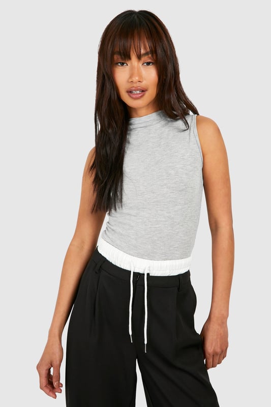 Sleeveless design for effortless layering
        Slash neckline adds a contemporary touch
        Melange fabric creates a subtle textured look
        Form-fitting silhouette accentuates curves
        Versatile piece suitable for various casual occasions
    
    This sleeveless melange body from Boohoo is the perfect foundation for countless casual ensembles. The form-fitting design hugs your curves in all the right places, while the slash neckline adds a modern twist to this wardrobe staple. Layer it under a chunky cardigan for a cosy day in or pair it with high-waisted trousers and trainers for a laid-back weekend look. The versatile nature of this piece makes it ideal for family gatherings, brunches with friends, or casual outings. For a trendy twist, throw on an oversized blazer and some statement jewellery to take this look from day to night. The melange fabric adds depth and interest, ensuring you'll stand out from the crowd in the most effortless way possible.