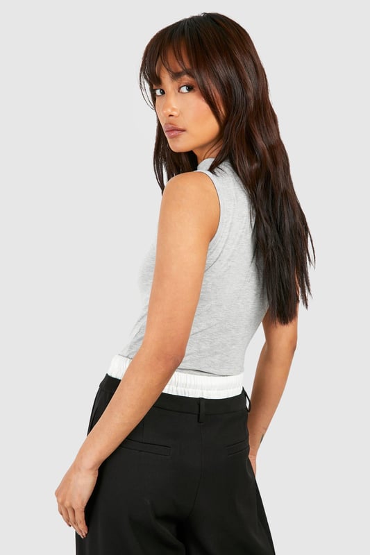 Sleeveless design for effortless layering
        Slash neckline adds a contemporary touch
        Melange fabric creates a subtle textured look
        Form-fitting silhouette accentuates curves
        Versatile piece suitable for various casual occasions
    
    This sleeveless melange body from Boohoo is the perfect foundation for countless casual ensembles. The form-fitting design hugs your curves in all the right places, while the slash neckline adds a modern twist to this wardrobe staple. Layer it under a chunky cardigan for a cosy day in or pair it with high-waisted trousers and trainers for a laid-back weekend look. The versatile nature of this piece makes it ideal for family gatherings, brunches with friends, or casual outings. For a trendy twist, throw on an oversized blazer and some statement jewellery to take this look from day to night. The melange fabric adds depth and interest, ensuring you'll stand out from the crowd in the most effortless way possible.