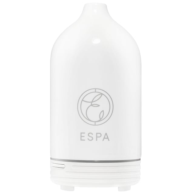 ESPA Aromatherapy Essential Oil Diffuser for Relaxation and Wellness Transform your living space with the ESPA Aromatherapy Essential Oil Diffuser. This stylish diffuser releases a mist of essential oils, enhancing your environment with soothing aromas that promote relaxation and well-being. It works seamlessly with ESPA's Signature Blends, helping you unwind or boost your mood. The ultrasonic technology humidifies the air and disperses fragrant vapor. With customizable light settings, it also serves as a gentle nightlight. To use, fill the water tank, add essential oil, select a misting mode, and enjoy the aromatic experience. (Essential oils sold separately.)