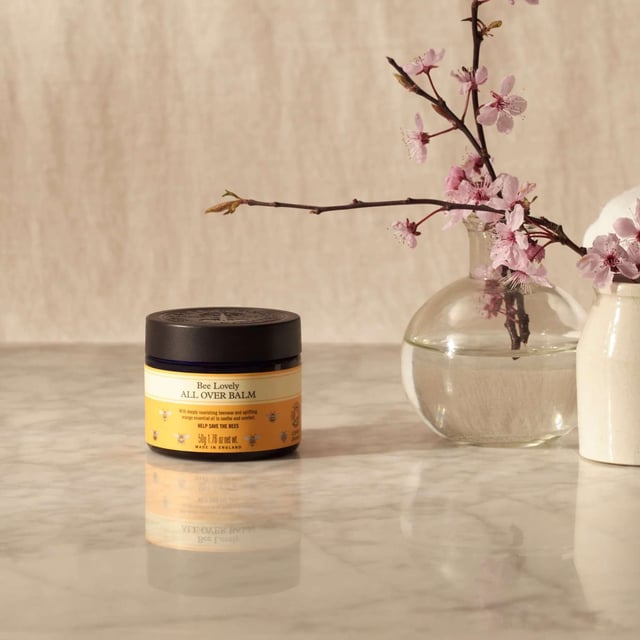 Neal's Yard Remedies Bee Lovely Moisturising Body Balm 50g - Organic Skin Care Discover the soothing power of Neal's Yard Remedies Bee Lovely All Over Balm. This luxurious 50g body balm contains 99.9% organic ingredients for deep nourishment to dry areas like elbows, knees, and feet. Infused with uplifting organic orange essential oil, it's perfect for keeping your skin soft and fragrant. Use it on hardworking hands, replenish skin overnight, or apply after swimming or outdoor activities. Neal's Yard Remedies is a pioneer in sustainable beauty, ensuring cruelty-free products made in an eco-friendly factory. Transform your skincare routine with this award-winning balm.