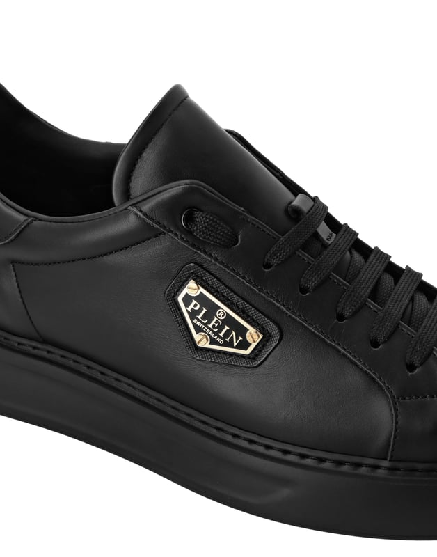 Deze low-top sneakers geven een verfijnd tintje aan streetwear en geven een gepolijste twist aan je off-duty look. Combineer ze met een getailleerde broek of denim van topkwaliteit voor een clean, zelfverzekerd silhouet.   Geheel vervaardigd van soepel kalfsleer voor een luxe uitstraling van binnen en buiten   Metalen logoplaatje voegt gedurfde identiteit en hoogwaardige details toe   Zachte lederen voering en binnenzool bieden blijvend comfort bij elke stap   Lichtgewicht EVA-zool zorgt voor modern gemak en flexibiliteit   Een veelzijdige staple voor chique casual styling of minimale monochrome edits