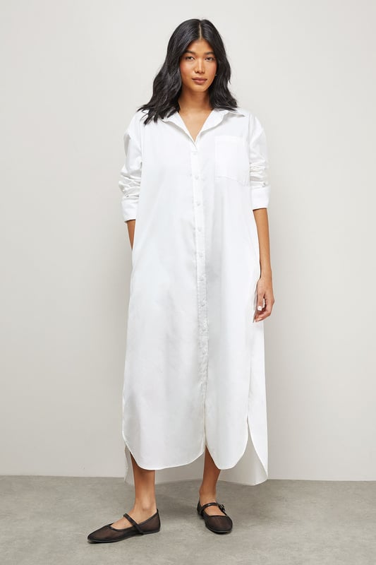 Oversized fit with dramatic side splits for effortless movement
        Midi length design with classic collar and full button-through front
        Long sleeves with buttoned cuffs for versatile styling options
        Relaxed dropped shoulders creating a contemporary silhouette
        Chest pocket detail adding subtle functional interest
    
    Make a statement with this Warehouse oversized midi shirt dress, the epitome of casual sophistication. The generous proportions and side splits create a flowing silhouette that moves beautifully with you, whilst the classic shirt detailing keeps the look grounded in timeless style. Perfect for family gatherings when paired with metallic flats as shown, or dress it down further with white trainers and a crossbody bag for weekend brunches. For cooler days, layer over slim-fit trousers and add a chunky knit cardigan. The cotton-rich fabric offers comfort for all-day wear, making this an ideal choice for those busy days when you need to look put-together with minimal effort. This versatile piece transitions effortlessly from casual daytime events to relaxed evening occasions - simply switch your accessories to refresh your look.