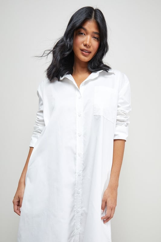 Oversized fit with dramatic side splits for effortless movement
        Midi length design with classic collar and full button-through front
        Long sleeves with buttoned cuffs for versatile styling options
        Relaxed dropped shoulders creating a contemporary silhouette
        Chest pocket detail adding subtle functional interest
    
    Make a statement with this Warehouse oversized midi shirt dress, the epitome of casual sophistication. The generous proportions and side splits create a flowing silhouette that moves beautifully with you, whilst the classic shirt detailing keeps the look grounded in timeless style. Perfect for family gatherings when paired with metallic flats as shown, or dress it down further with white trainers and a crossbody bag for weekend brunches. For cooler days, layer over slim-fit trousers and add a chunky knit cardigan. The cotton-rich fabric offers comfort for all-day wear, making this an ideal choice for those busy days when you need to look put-together with minimal effort. This versatile piece transitions effortlessly from casual daytime events to relaxed evening occasions - simply switch your accessories to refresh your look.