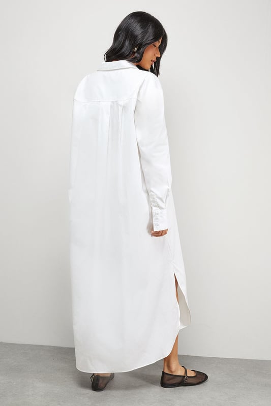 Oversized fit with dramatic side splits for effortless movement
        Midi length design with classic collar and full button-through front
        Long sleeves with buttoned cuffs for versatile styling options
        Relaxed dropped shoulders creating a contemporary silhouette
        Chest pocket detail adding subtle functional interest
    
    Make a statement with this Warehouse oversized midi shirt dress, the epitome of casual sophistication. The generous proportions and side splits create a flowing silhouette that moves beautifully with you, whilst the classic shirt detailing keeps the look grounded in timeless style. Perfect for family gatherings when paired with metallic flats as shown, or dress it down further with white trainers and a crossbody bag for weekend brunches. For cooler days, layer over slim-fit trousers and add a chunky knit cardigan. The cotton-rich fabric offers comfort for all-day wear, making this an ideal choice for those busy days when you need to look put-together with minimal effort. This versatile piece transitions effortlessly from casual daytime events to relaxed evening occasions - simply switch your accessories to refresh your look.