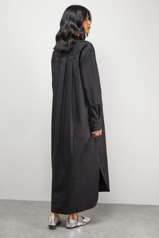 Oversized fit with dramatic side splits for effortless movement
        Midi length design with classic collar and full button-through front
        Long sleeves with buttoned cuffs for versatile styling options
        Relaxed dropped shoulders creating a contemporary silhouette
        Chest pocket detail adding subtle functional interest
    
    Make a statement with this Warehouse oversized midi shirt dress, the epitome of casual sophistication. The generous proportions and side splits create a flowing silhouette that moves beautifully with you, whilst the classic shirt detailing keeps the look grounded in timeless style. Perfect for family gatherings when paired with metallic flats as shown, or dress it down further with white trainers and a crossbody bag for weekend brunches. For cooler days, layer over slim-fit trousers and add a chunky knit cardigan. The cotton-rich fabric offers comfort for all-day wear, making this an ideal choice for those busy days when you need to look put-together with minimal effort. This versatile piece transitions effortlessly from casual daytime events to relaxed evening occasions - simply switch your accessories to refresh your look.
