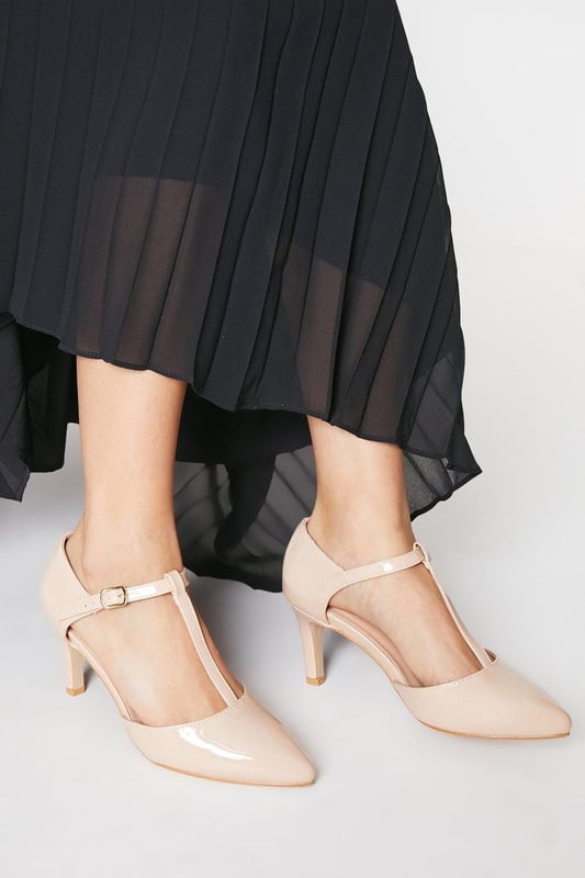 Elegant T-bar design with adjustable ankle strap for secure fit
        Pointed toe silhouette creates a flattering, elongated look
        Extra wide fit specially designed for enhanced comfort
        High heel measuring between 7-9cm adds sophisticated height
        Faux leather finish offers a polished, versatile appearance
    
    The Emma court shoes from Good For The Sole combine timeless style with exceptional comfort. Designed specifically with an extra wide fit, these pointed courts feature a classic T-bar strap that adds a touch of vintage charm while providing additional support. The high heel creates an elegant silhouette without compromising on wearability, making these courts perfect for daytime events where you want to make an impression. Style them with tailored trousers and a crisp blouse for family gatherings, or pair with a flowing midi skirt for casual lunches with friends. The neutral tone makes these courts incredibly versatile, allowing them to complement virtually any outfit in your wardrobe. The secure ankle strap ensures stability while the pointed toe design conveys sophistication, striking the perfect balance between fashion and function.