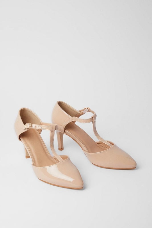 Elegant T-bar design with adjustable ankle strap for secure fit
        Pointed toe silhouette creates a flattering, elongated look
        Extra wide fit specially designed for enhanced comfort
        High heel measuring between 7-9cm adds sophisticated height
        Faux leather finish offers a polished, versatile appearance
    
    The Emma court shoes from Good For The Sole combine timeless style with exceptional comfort. Designed specifically with an extra wide fit, these pointed courts feature a classic T-bar strap that adds a touch of vintage charm while providing additional support. The high heel creates an elegant silhouette without compromising on wearability, making these courts perfect for daytime events where you want to make an impression. Style them with tailored trousers and a crisp blouse for family gatherings, or pair with a flowing midi skirt for casual lunches with friends. The neutral tone makes these courts incredibly versatile, allowing them to complement virtually any outfit in your wardrobe. The secure ankle strap ensures stability while the pointed toe design conveys sophistication, striking the perfect balance between fashion and function.
