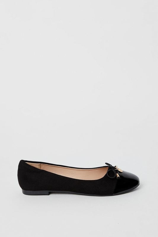 Elegant ballet pumps featuring a glossy toecap with decorative bow and charm detail
        Flat heel design measuring between 0-2cm for all-day comfort
        Soft faux leather construction with cushioned insole for enhanced wearability
        Part of the Good For the Sole collection, designed with comfort in mind
        Regular fit with rounded toe shape for a classic silhouette
    
    These charming Tash ballet pumps strike the perfect balance between professional polish and feminine style. The distinctive glossy toecap and delicate bow with metal charm detail add a touch of sophistication to this workplace essential. Pair with tailored trousers and a crisp blouse for office meetings, or team with a pencil skirt for a refined daytime look. The flat design ensures comfort throughout your busy day without compromising on style. For casual Fridays, these versatile pumps complement slim-fit jeans and a structured blazer beautifully. The cushioned insole provides welcome support during long days, making these ballet pumps an indispensable addition to your workwear wardrobe. Transition effortlessly from day to evening by swapping your work attire for a smart dress - these timeless flats will complement virtually any ensemble.
