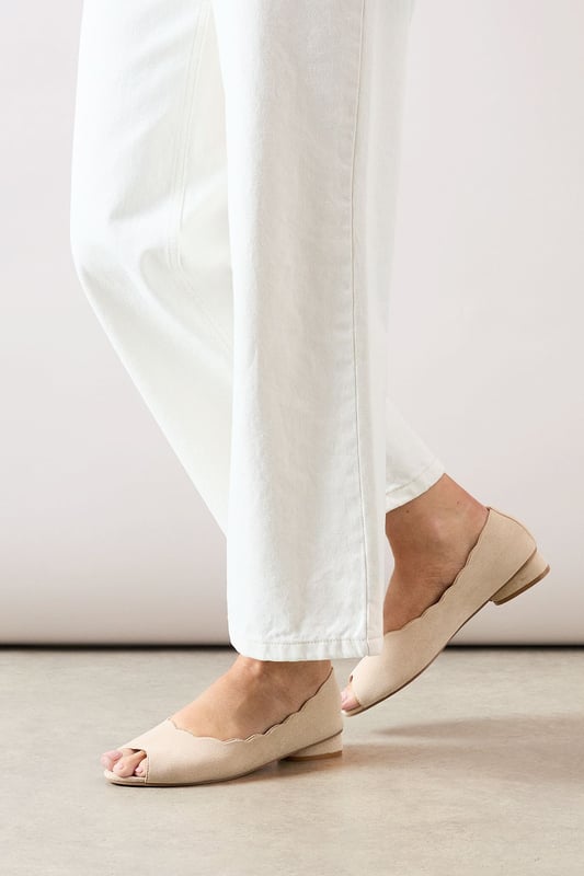 Elegant peeptoe design with distinctive scalloped edging for a feminine touch
        Comfortable low heel measuring between 2.5-4.5cm perfect for all-day wear
        Soft faux suede finish that adds texture and sophistication
        Part of the Good For The Sole collection, designed with comfort in mind
        Versatile slip-on style with a flattering silhouette that complements various outfits
    
    The Solane pumps from Good For The Sole combine style and practicality in one chic package. The delicate scalloped edging creates visual interest whilst the peeptoe design offers a subtle glimpse of personality. These versatile flats pair beautifully with tailored trousers as shown, but work equally well with floaty midi skirts or cropped jeans for casual daywear. The modest heel height provides just enough elevation without sacrificing comfort, making these ideal for family gatherings, weekend brunches or office days that extend into evening drinks. The slip-on design ensures effortless wear, whilst the soft faux suede finish adds a touch of luxury to your everyday wardrobe. Style with wide-leg trousers and a crisp blouse for an elegant daytime look, or team with a casual dress for garden parties and informal gatherings.