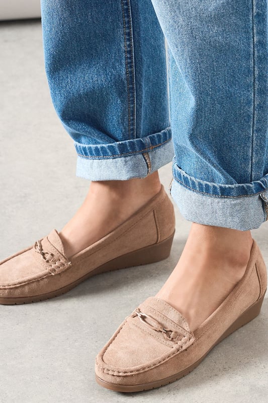 Faux suede moccasin loafers with decorative trim detail for a classic finish
        Subtle wedge heel (under 2cm) provides gentle lift without sacrificing comfort
        Cushioned footbed designed specifically for all-day wear
        Slip-on style with moccasin stitching for effortless everyday dressing
        Part of our Good For The Sole collection, crafted with comfort in mind
    
    These Viridiana moccasin loafers blend timeless style with exceptional comfort, making them a wardrobe essential for the modern woman. The subtle wedge provides just enough height to flatter without compromising on wearability, whilst the faux suede texture adds a touch of sophistication to casual ensembles. Style them with rolled-up jeans for a relaxed weekend look, or pair with tailored trousers and a crisp shirt for smart-casual office days. The versatile design works beautifully with everything from floaty midi dresses to cropped trousers, making these loafers perfect for family gatherings, casual brunches, or those busy days when you're on your feet. The thoughtful comfort features ensure these will quickly become your go-to footwear choice when you need both style and practicality.