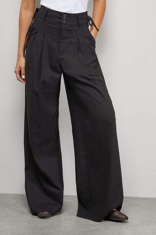 Tailored wide-leg silhouette with dramatic floor-sweeping length
        Front pleats for added structure and dimension
        Practical side pockets for everyday functionality
        Secure button and clasp waistband closure
        Linen blend fabric offering breathable comfort with a refined drape
    
    Make a confident statement with these Warehouse tailored trousers that combine contemporary styling with everyday wearability. The wide-leg design creates a flowing silhouette that moves beautifully with every step, while the structured pleats add a touch of sophistication. These versatile trousers transition effortlessly from day to evening - pair with a crisp white t-shirt and oversized shirt for a relaxed daytime look, or style with a fitted bodysuit and statement jewellery for dinner with friends. The linen blend fabric ensures these trousers maintain their shape whilst offering breathability for all-day comfort. Complete the ensemble with chunky loafers or trainers for an edgy, modern finish that captures Warehouse's confident aesthetic. Perfect for family gatherings, weekend brunches or casual workplace settings where comfort meets style.