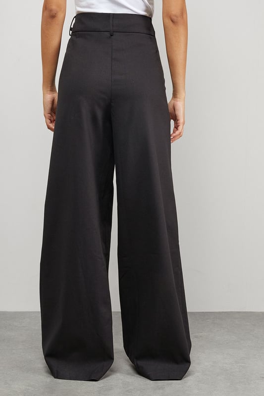 Tailored wide-leg silhouette with dramatic floor-sweeping length
        Front pleats for added structure and dimension
        Practical side pockets for everyday functionality
        Secure button and clasp waistband closure
        Linen blend fabric offering breathable comfort with a refined drape
    
    Make a confident statement with these Warehouse tailored trousers that combine contemporary styling with everyday wearability. The wide-leg design creates a flowing silhouette that moves beautifully with every step, while the structured pleats add a touch of sophistication. These versatile trousers transition effortlessly from day to evening - pair with a crisp white t-shirt and oversized shirt for a relaxed daytime look, or style with a fitted bodysuit and statement jewellery for dinner with friends. The linen blend fabric ensures these trousers maintain their shape whilst offering breathability for all-day comfort. Complete the ensemble with chunky loafers or trainers for an edgy, modern finish that captures Warehouse's confident aesthetic. Perfect for family gatherings, weekend brunches or casual workplace settings where comfort meets style.