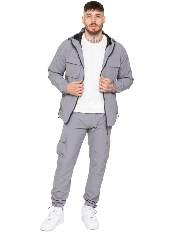Gear up with the Enzo Milano Men’s Lightweight Cargo Jacket & Pants Set, built for comfort, function, and style. The jacket features water-repellent crushed poly fabric with a breathable mesh lining, full zip front, adjustable hood, and multiple secure pockets. Paired with lightweight cargo pants in a regular fit, this set includes an elasticated waistband with drawstring, cargo pockets, and adjustable hems for a personalized fit.