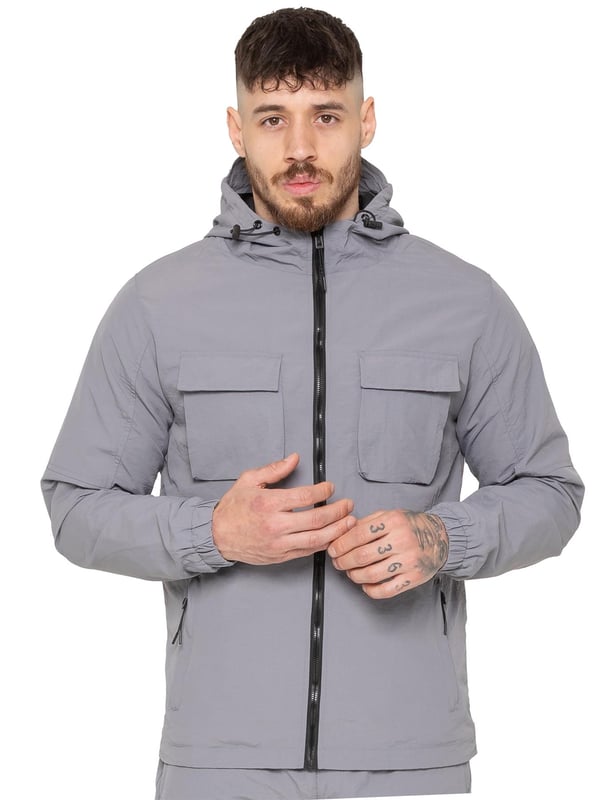 Gear up with the Enzo Milano Men’s Lightweight Cargo Jacket & Pants Set, built for comfort, function, and style. The jacket features water-repellent crushed poly fabric with a breathable mesh lining, full zip front, adjustable hood, and multiple secure pockets. Paired with lightweight cargo pants in a regular fit, this set includes an elasticated waistband with drawstring, cargo pockets, and adjustable hems for a personalized fit.