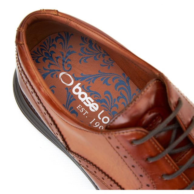 Base London Flight 25 Herren Brogues Aus Gebranntem Tan Leder Dieser superleichte Brogue von Base London integriert die neuesten Sohlentechnologien in klassisches britisches Design, um jeden Schritt federleicht zu machen. Gleiten Sie stilvoll zur Arbeit oder schneiden Sie auf der Tanzfläche einige Figuren, Flight wird Sie dorthin bringen.