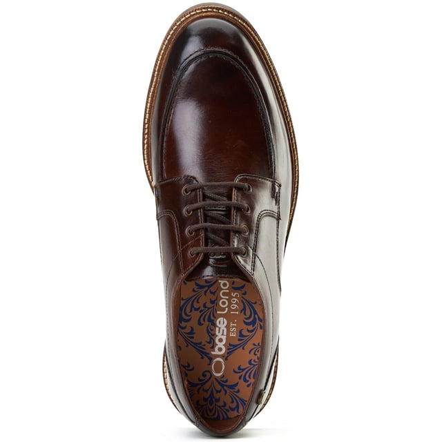 Base London Surrey Leder Herren Schnürschuhe Burnt Brown Fügen Sie Ihrer Garderobe mit den Surrey-Schuhen von Base London etwas Abwechslung hinzu. Hergestellt aus hochwertigem Leder, hebt die Schürze und die Ziernähte diesen eleganten Schuh von Ihrem alltäglichen Brogue oder Derby ab. Enthält eine Ortholite-Einlegesohle für zusätzlichen Komfort.