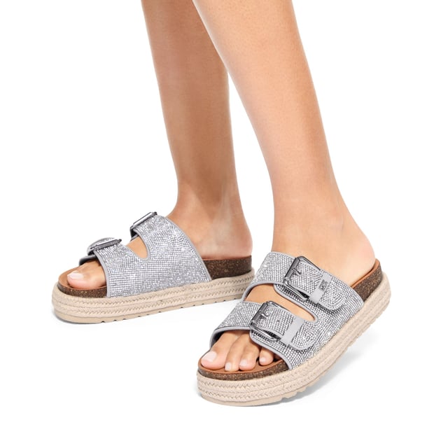 This KG Kurt Geiger Raquel Gem is a slip-on sandal with silver crystal embellishment across both of the straps. The straps are fastened with silver buckles and the sole is in a rope style.