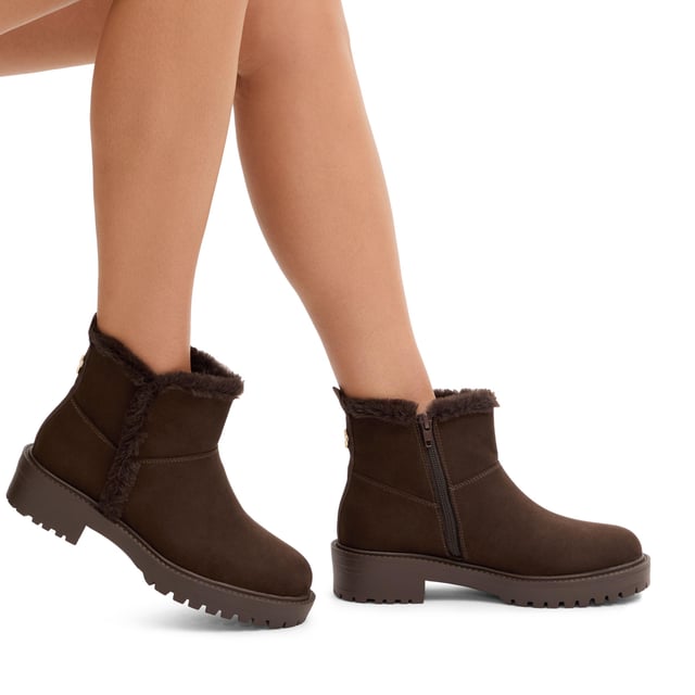 This Carvela Cosy Ankle boot features a brown microsuede upper with faux fur lining on the interior. There is a gold Icon C at the back of the ankle.